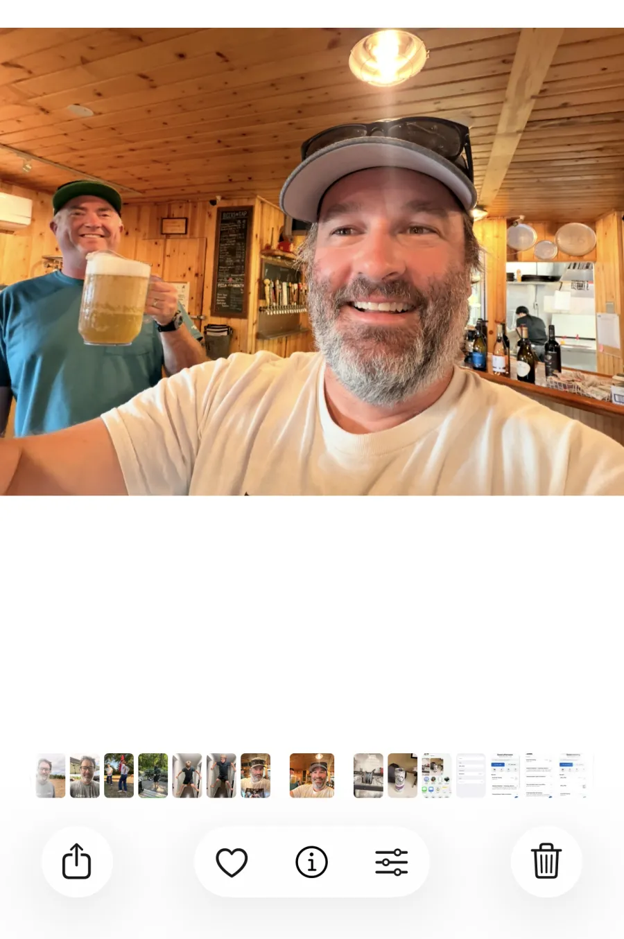 A photo open in the iOS Photos app, with the share button in the bottom-left corner of the toolbar.